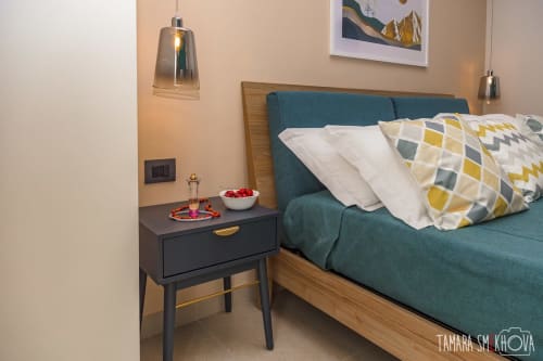 Camera Nerello a Macramè Fazello a Sciacca con letto imbottito teal, struttura in legno, cuscini decorati, comodino nero e