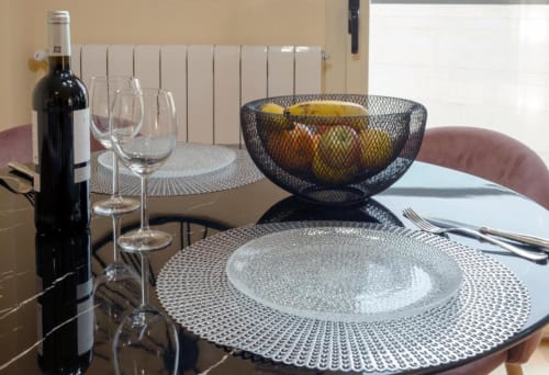 Elegante montaje de comedor en el apartamento La Quinta Esencia de Burgos con vino, copas, frutero y cubierto sobre la mesa