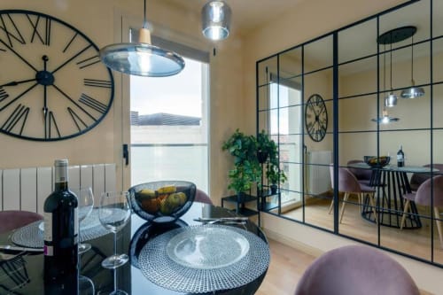 Comedor de apartamento moderno en Burgos con patrones geométricos, iluminación contemporánea y espejos de piso a techo