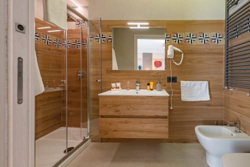 Bagno moderno nella Suite Nero D'avola di Macramè Fazello a Sciacca con vanità in legno, doccia, bidet e amenities