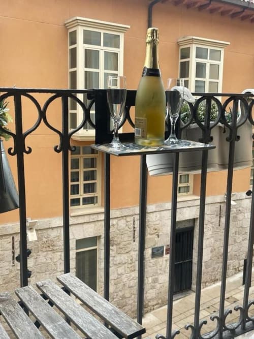 Botella de champagne y copas en la terraza del apartamento Valeria's Corner con vistas a la arquitectura de Burgos