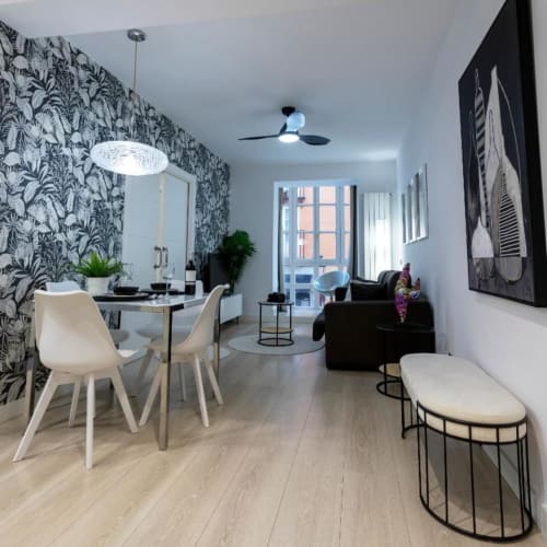 Interior moderno del apartamento Spacio Menina en Burgos con comedor, sala, cocina y papel tapiz botánico
