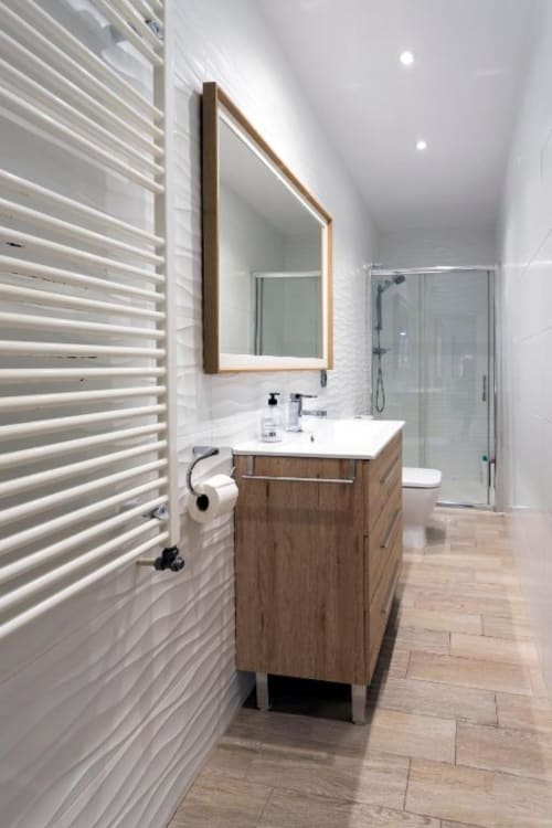 Baño moderno del apartamento Spacio Menina en Burgos con tocador de madera, espejo enmarcado y ducha de entrada