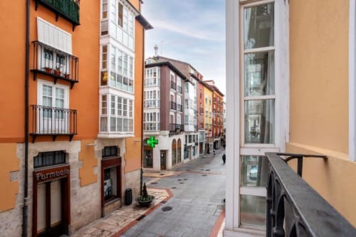 Encantadora calle adoquinada en Burgos con coloridos edificios históricos con alquiler de apartamentos Unique Rooms