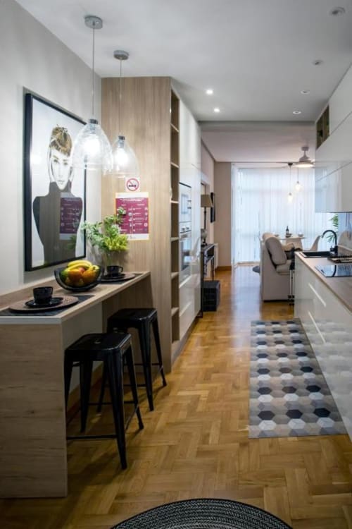 Cocina y comedor modernos en el apartamento Audrey de Unique Rooms Burgos con detalles de madera, lámparas colgantes y vistas a la ciudad