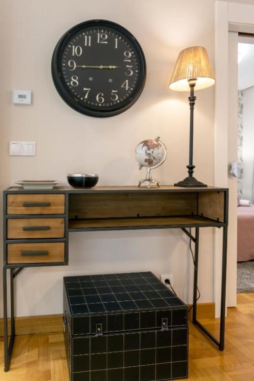 Escritorio moderno con cajones de madera y lámpara negra en el apartamento Audrey, Burgos, España