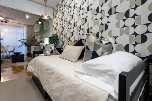 Dormitorio moderno en Audrey by Unique Rooms en Burgos con patrón geométrico en la pared, ropa de cama blanca y vistas a la ciudad