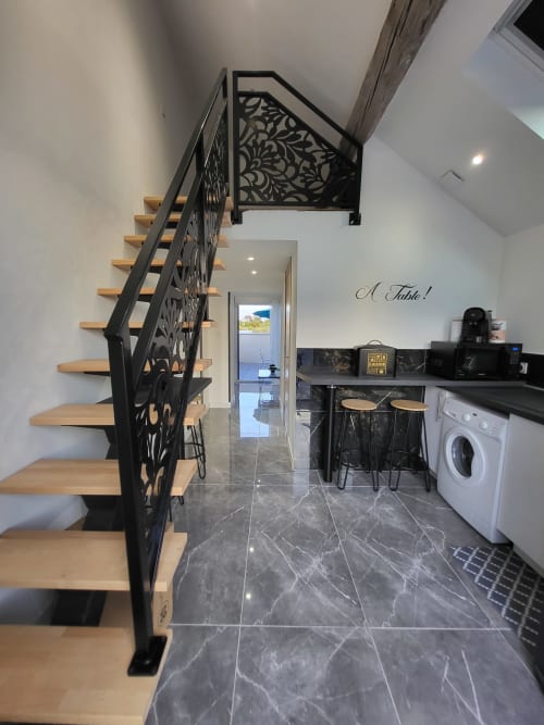 Escalier moderne avec rampe noire décorative dans la cuisine des Gîtes Les Camélias 71, Oslon France