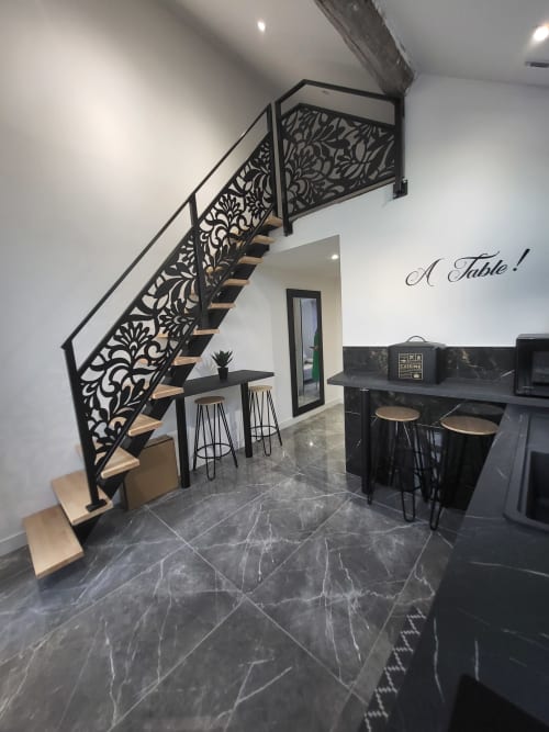 Escalier moderne avec rampe noire ornementale dans la salle à manger des Gites Les Camelias 71, Oslon