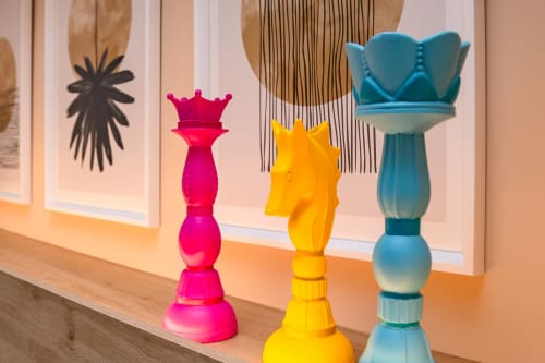 Coloratissimi pezzi di scacchi decorativi in rosa, giallo e blu su scaffale in legno all'hotel Macramè Fazello, Sciacca.