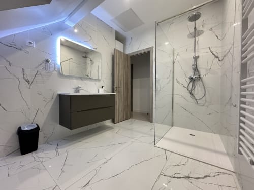 Salle de bain moderne en marbre avec douche à l'italienne aux Gîtes Les Camélias 71, Oslon, miroir lumineux et vasque noire