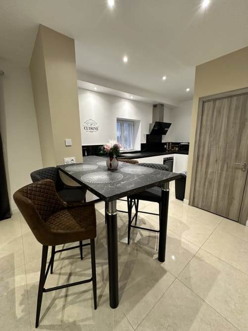 Espace ouvert cuisine-salle à manger moderne aux Gîtes Les Camélias 71 à Oslon avec coin bar et mobilier contemporain