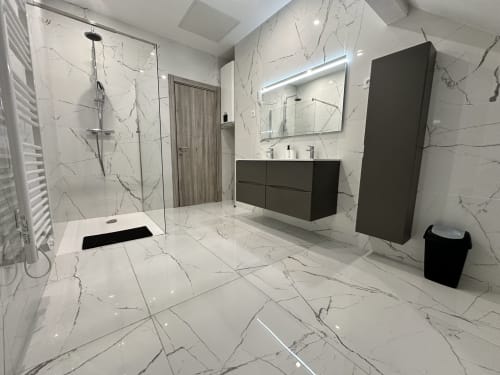Salle de bain moderne en marbre aux Gites Les Camelias 71 avec douche à l'italienne, vasque noire et sèche-serviettes électrique