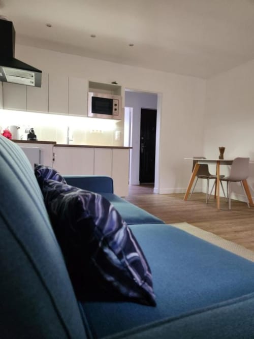 Studio moderne à l'Appart Hôtel Panambi à Chevilly-Larue avec canapé bleu, cuisine et coin repas