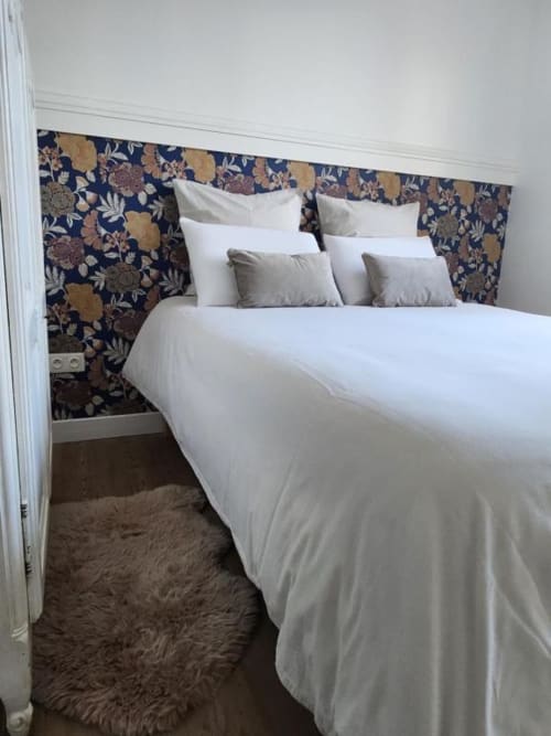 Habitació moderna amb roba de llit blanca i capçal floral a l'Appart Hôtel Panambi, allotjament a Chevilly-Larue