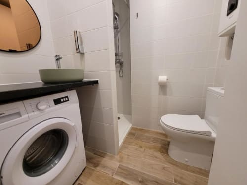 Salle de bains moderne de l'appartement Appart Hôtel Panambi avec toilettes, lave-linge, lavabo et douche