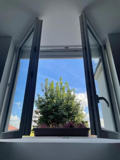 Fenêtre ouverte à l'Appart Hôtel Panambi donnant sur le jardin et le ciel à Chevilly-Larue