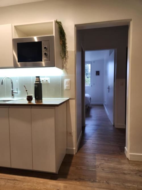 Kitchenette moderne avec micro-ondes, évier et mobilier blanc à l'Appart Hôtel Panambi, Chevilly-Larue