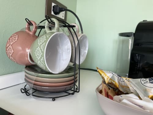 Supporto decorativo per tazze con tazze in ceramica rosa e bianche nella cucina dell'appartamento San Giacomo degli Schiavoni