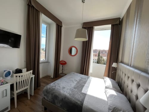 Camera matrimoniale moderna a Michelangelo Suite Roma con vista sulla città, arredi contemporanei e palette neutra