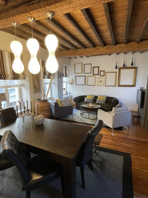 Espace de vie ouvert et moderne aux Gites Boulogne Sur Mer avec table à manger, coin salon, poutres en bois apparent et luminaire