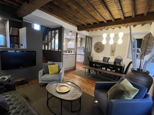 Séjour moderne du gîte Boulogne-sur-Mer avec coin salon, télévision, espace repas et poutres apparentes