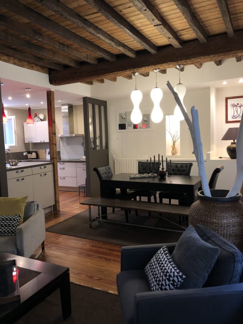 Cottage moderne ouvert à Boulogne-sur-Mer avec poutres apparentes, coin repas, mobilier noir et luminaires suspendus