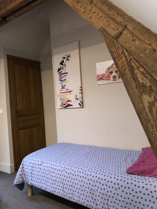 Chambre cosy du gîte Boulogne Sur Mer avec literie à pois, plafond aux poutres apparentes et tableau de chien sur murs blancs