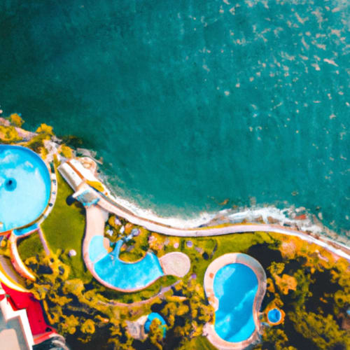Aerial view of Isla Tajín Beach Resort's colorful pools and coastline along turquoise waters in Tuxpan, Mexico