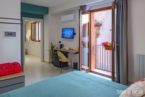 Camera Perricone a Macramè Fazello a Sciacca con letto turchese, scrivania, TV e balcone con vista sulla città