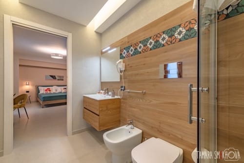 Bagno moderno con vanità in legno e doccia nella Perricone Room di Macramè Fazello a Sciacca, Sicilia
