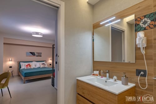 Bagno della Camera Perricone presso Macramè Fazello a Sciacca con vanità in legno, specchio e vista sulla città dalla camera da letto