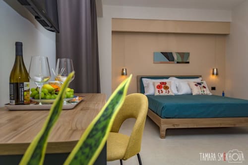 Studio moderno a Macramè Fazello, Sciacca: sedia gialla, scrivania in legno con vino, letto turchese con vista sulla città