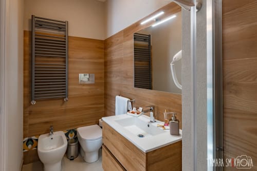Bagno moderno nella Stanza Nerello di Macramè Fazello, Sciacca con pareti in legno, scaldasalviette e specchio illuminato