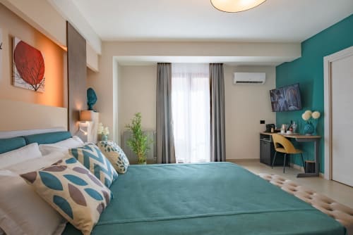 Camera moderna a Macramè Fazello a Sciacca con parete azzurra, letto queen, scrivania e vista sulla città dal balcone