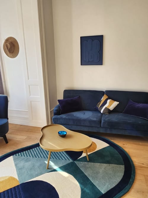 Salon moderne des Gîtes Boulogne Sur Mer avec canapé bleu marine, table basse ronde et tapis géométrique