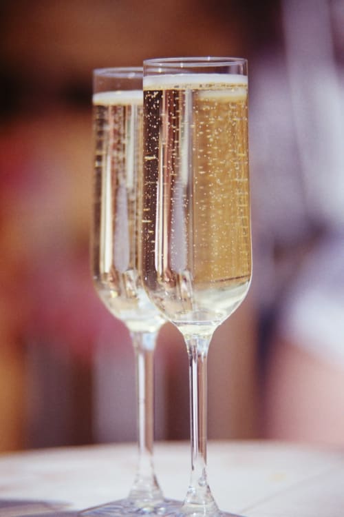 Dos copas de champagne con vino espumante en Hotel Fiori Roma, listas para celebrar