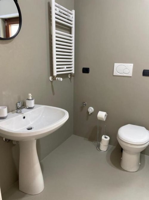 Bagno moderno nell'appartamento La Maison Srls a Bari con lavabo colonna, wc, scaldasalviette e accessori