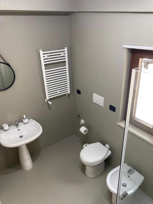 Bagno moderno dell'appartamento La Maison Srls a Bari con lavabo a colonna, wc, scaldarughe e box doccia