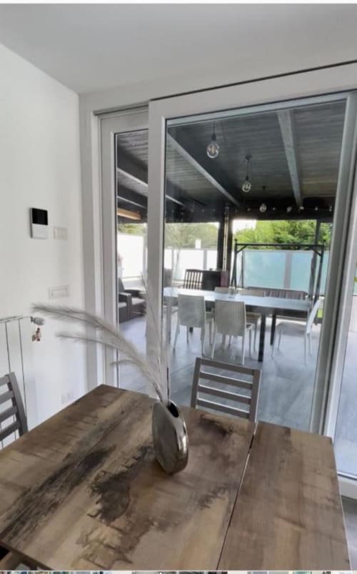 Zona pranzo di villa moderna con porte vetrate che si aprono sul giardino, La Maison Srls, Bari