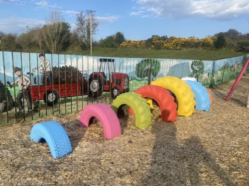 Colorful play equipment and tire obstacles at Duffy Lodge's outdoor playground in Co Donegal