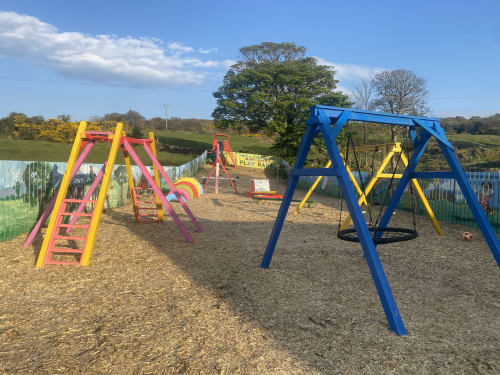 Colorful playground with slides and swings at Duffy Lodge, Co Donegal, perfect for families with children.