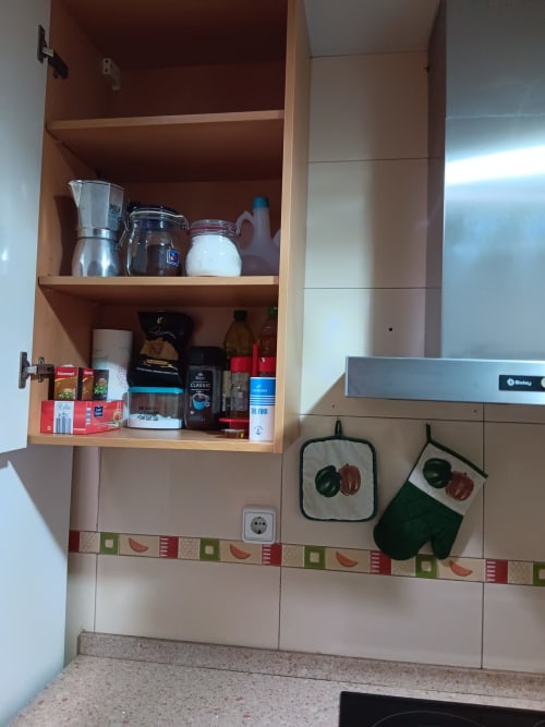Kitchen cabinet with coffee maker, pantry items, and cooking supplies in Casa Ferrer Barcelona apartment