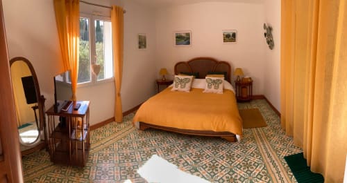 Chambre double Luberon du Domaine des Lavarines à Avignon avec literie orange, mobilier en bois et vue sur le jardin