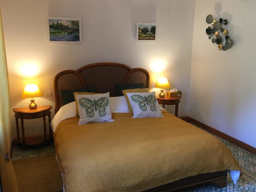 Chambre double Luberon à Domaine des Lavarines avec lit queen-size, tête de lit en rotin, oreillers papillon et vue sur le jardin