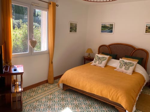 Chambre double Luberon lumineuse au Domaine des Lavarines avec couvre-lit doré, vue sur le jardin et décor français traditionnel