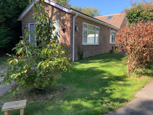 Sunbeam Haven 2BR bungalow with brick exterior, manicured garden, and climbing ivy in High Wycombe
