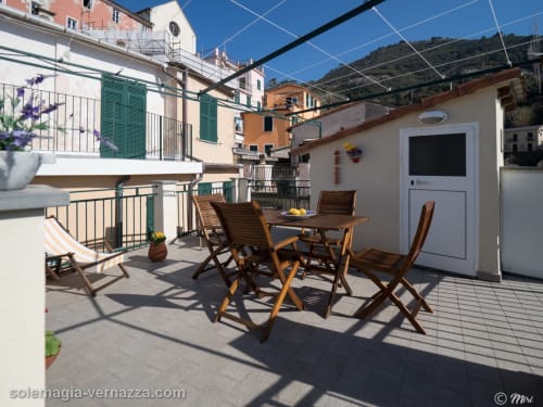 Terrazza panoramica SoleMagia a Vernazza con arredi in legno, vista mare e tipiche case colorate italiana