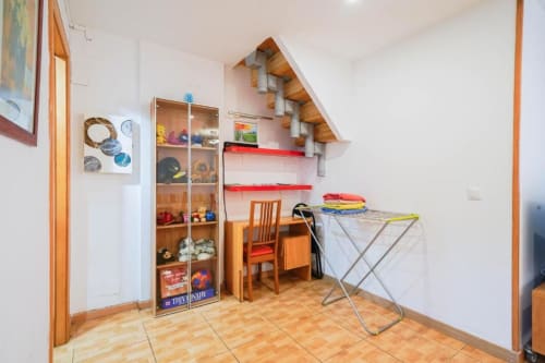 Cuarto de servicio en Casa Ferrer Barcelona con estanterías, tendedero y muebles de madera en L'Hospitalet de Llobregat
