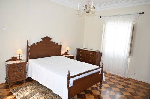 Chambre élégante à la Villa Sor à Ponte de Sor avec lit à quatre colonnes ancien, draps blancs, mobilier en bois foncé